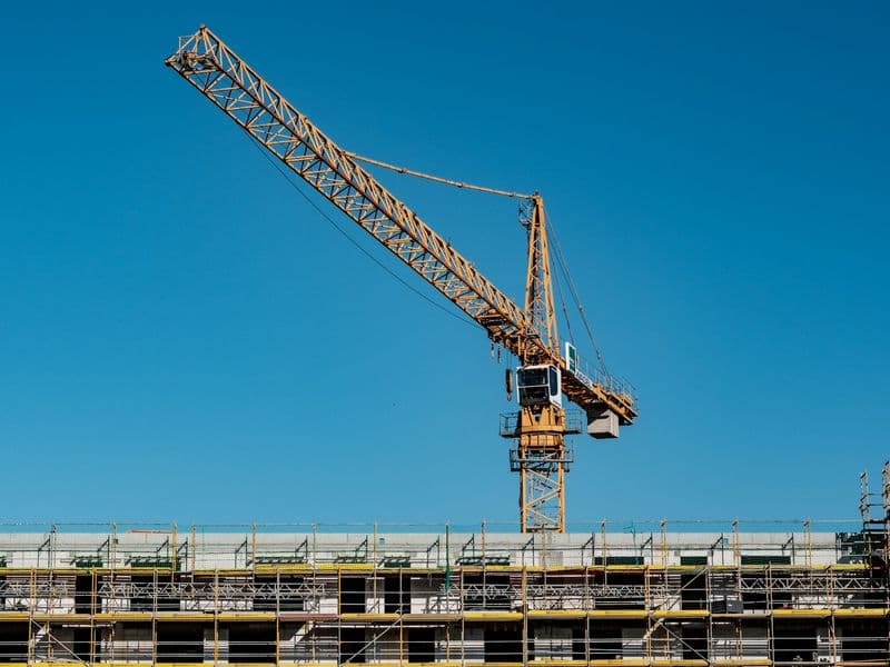 Betonarme şantiyesinin üzerinde çalışan sarı kule vinç
